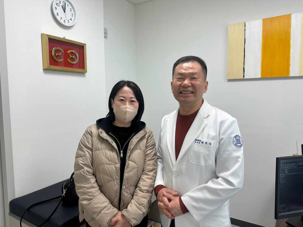 박진수 대표원장과 환자가 진료실에서 기념촬영한 모습